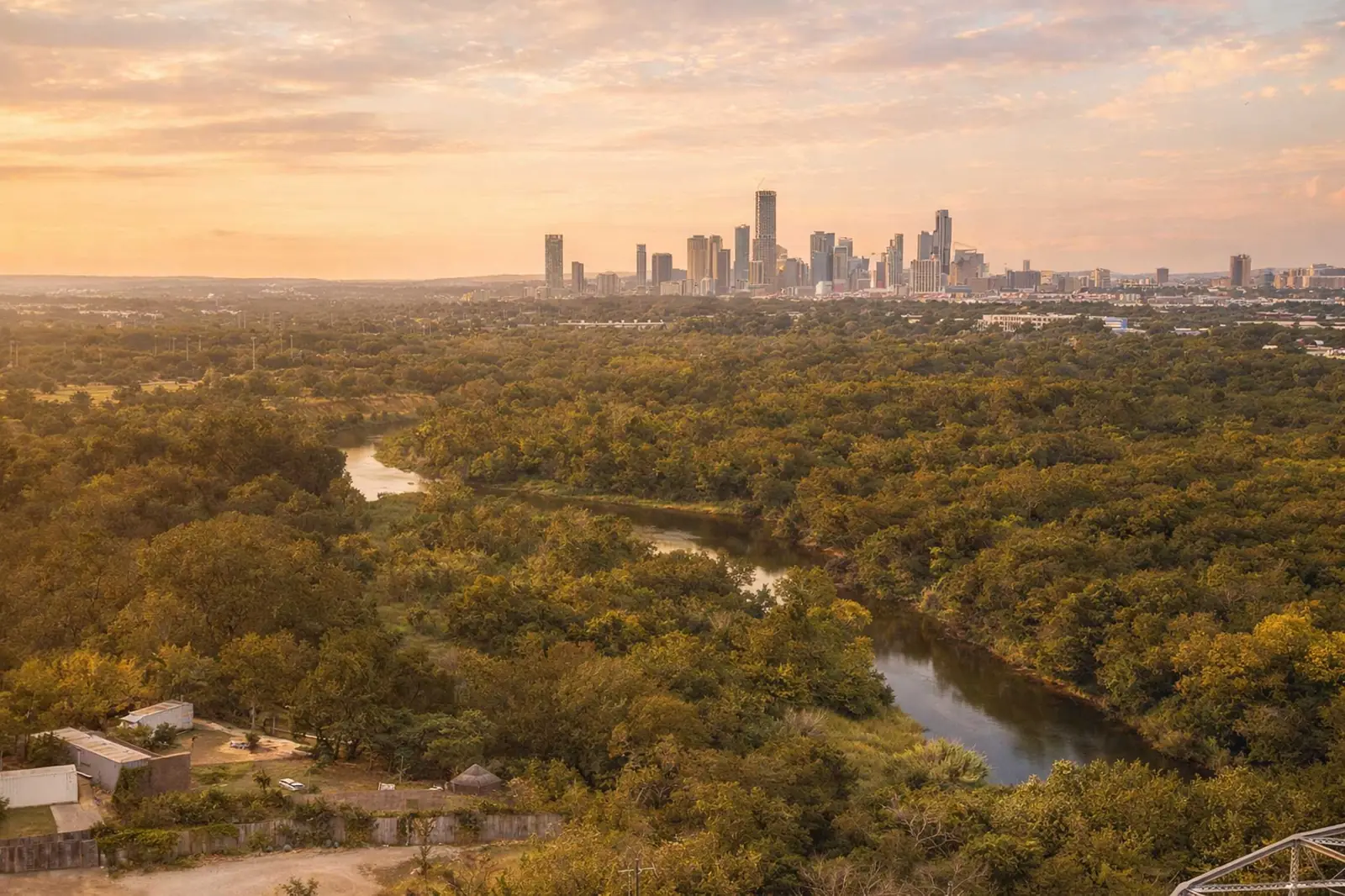 Aerial view of the Colorado River, surrounding parkland, and the downtown Austin skyline